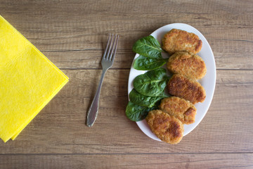 Delicious cutlets with spinach on white plate