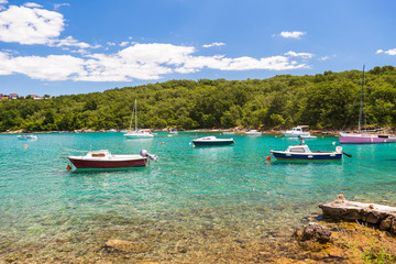 Fototapeta na wymiar Boats in a turquoise water in a bay near Malinska, Croatia. Summer holidays, travel concept. Boats in Mediterranean Sea. Tourists boats in Adriatic sea.