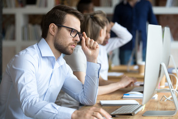 Confident pensive employee working in shared office