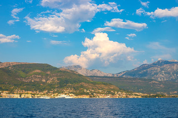 Incredible bright seascape. View of green wooded mountains and blue sea, blue sky and white clouds. Boka Kotorska Bay, Montenegro