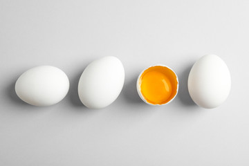 Chicken eggs and half with yolk on white background, space for text