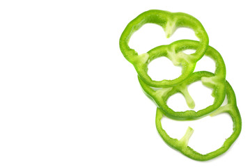 cut slices of green sweet bell pepper isolated on white background top view