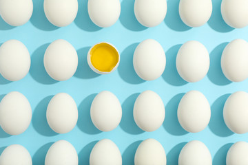 Flat lay composition with chicken eggs and half with yolk on color background, space for text