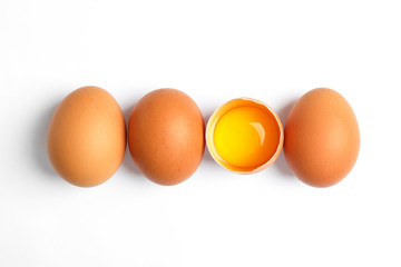 Chicken eggs and half yolk on white background, space for text
