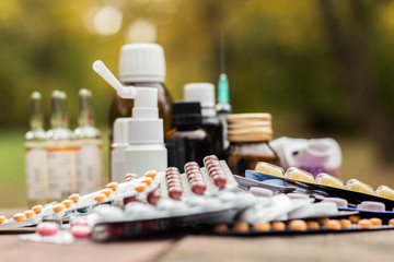Medicines on wooden table, nature bokeh background
