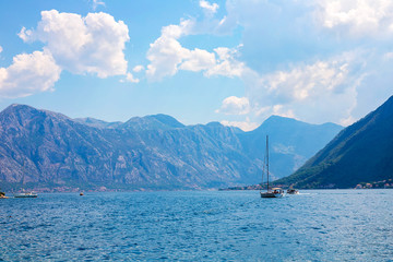 Incredible bright seascape. View of green wooded mountains and blue sea, blue sky and white clouds. Boka Kotorska Bay, Montenegro