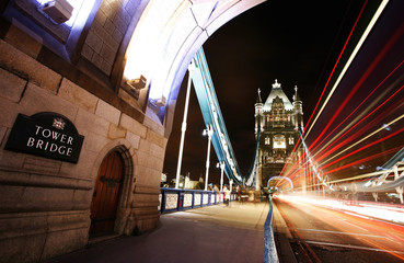 Obraz premium Tower Bridge at night with bus light trails.