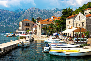 Fototapeta premium Scenic panoramic view of the historical city of Perast, located in the Bay of Kotor on a sunny day with blue sky and white clouds in summer, Montenegro, southern Europe
