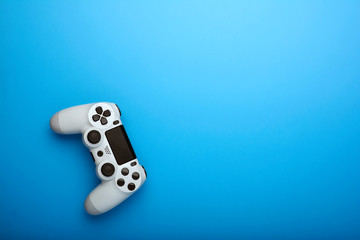White console gamepad, game controller on blue texture background. Copy space for text.