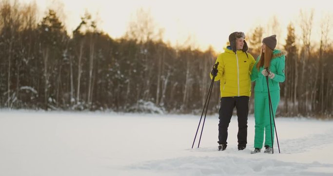 Look at each other with loving eyes while skiing in the winter forest. a married couple practices a healthy lifestyle