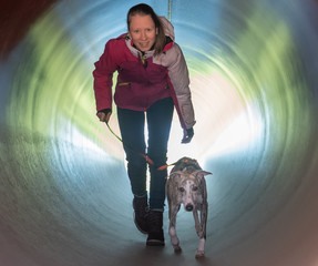 hinabsteigen, Mädchen geht mit Hund durch einen Tunnel
