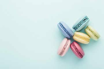 Colorful macarons on turquoise background. Top view, close up.