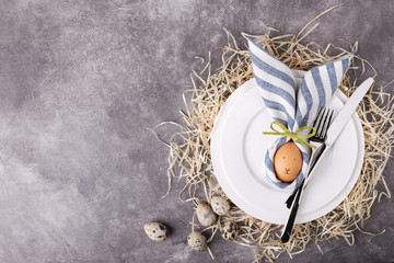 Beautiful Easter table setting with egg in napkin Easter Bunny. Top view.