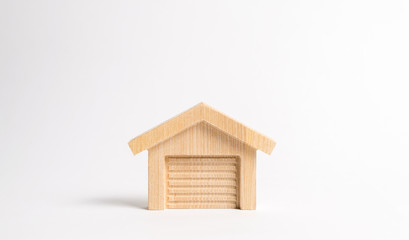 Obraz na płótnie Canvas Wooden figure of a garage or warehouse. The concept of starting a new business, workshop in the garage. Inventions and innovations. Sale of garages and parking lots for cars.