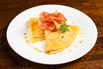 crepes with bacon ont he wooden background