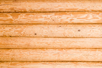 Wall of wooden houses built of round logs