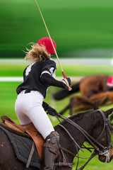 Polo woman player is riding on a horse, close-up.