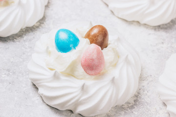 Fototapeta na wymiar Close-up of pastel colored chocolate Easter egg candy with white meringue