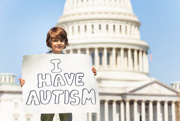 Protester holding sign I have autism in hands