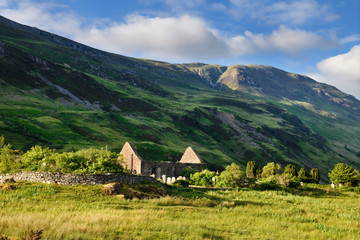 Ruins of St Dubhthach's Church next to Clachan Duich Burial Ground at head of Loch Duich under Beinn Bhreac peak in evening light Scotland