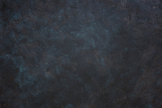 Textured dark rough background with blue and yellow spots