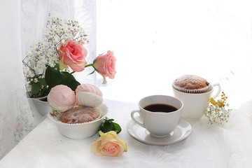 A cup of coffee and flowers on a light background, wishes of good morning and good day, a cozy home