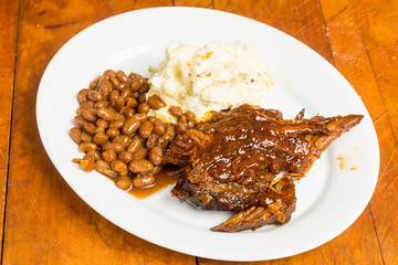 Barbecue Beef Brisket on Platter with Beans and Potato Salad in Rustic Setting