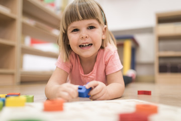 Smiling kid playing and learning alphabet