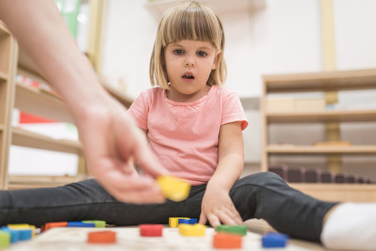 Teacherlearning child in kindergarten with educational games