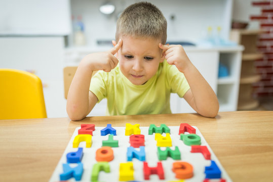 Thinking little boy solve puzzle