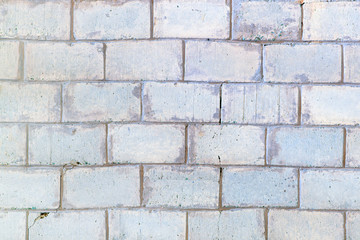Background with brickwork texture. Light gray wall lined with large bricks.