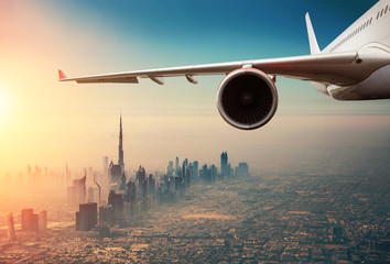 Commercial jet plane flying above Dubai city