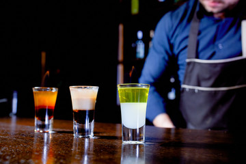 Fiery show at the bar. The bartender makes hot alcoholic cocktail and ignites bar. Bartender prepares a fiery cocktail. Fire on bar.