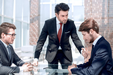 annoyed businessman scolds his employees