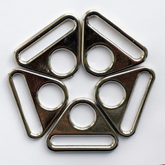 Metal accessories of a bag and backpack production from metal, lined in a circle, shiny silver color of a triangular shape