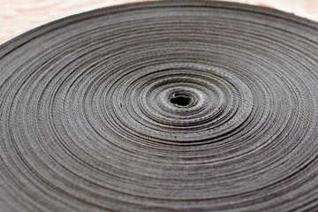 A belt of dark color on a production scale for the manufacture of safety belts or bags. Belt Coil Gray