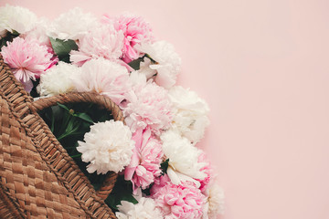  Happy mothers day. Greeting card mockup. Stylish  straw rustic basket with pink and white peonies on pink paper flat lay with space for text. Hello summer. International womens day.