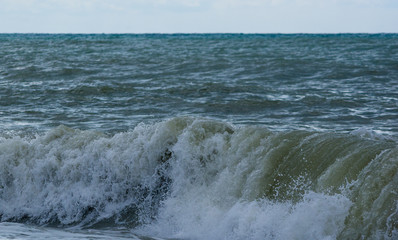 sea landscape is a pebbly beach with waves in white foam