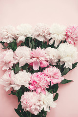 Stylish pink and white peonies bouquet on pink paper flat lay. Creative floral image. Happy mother's day. International womens day. Greeting card mockup.