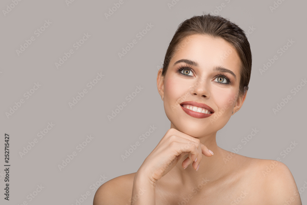 Wall mural Portrait of young woman. Perfect clean skin and beautiful smile. Gray background.