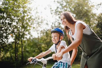 Sister and little brother learning to ride bicycle park having fun together.