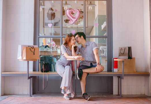 Asian couple sitting and talking happily after shopping.