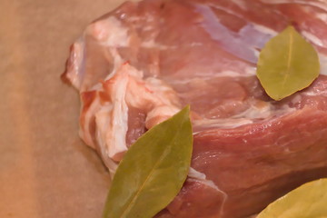 A piece of fresh pig meat with Laurel leaves