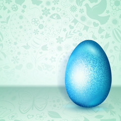 Big light blue Easter egg standing on green background of flowers, cakes, hare, chicken and other holiday symbols