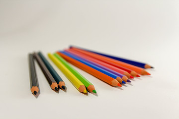 Multiple colored pencils on a white background.