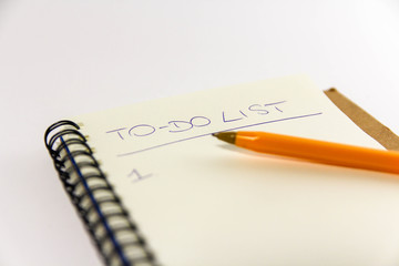 To do list in spiral notepad. White background, flat lay style.