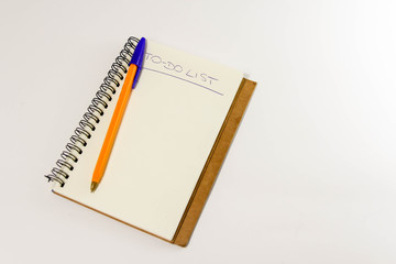 To do list in spiral notepad. White background, flat lay style.