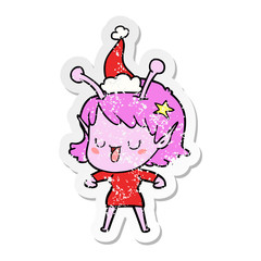 happy alien girl distressed sticker cartoon of a wearing santa hat
