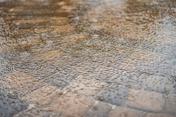 heavy rain on water that is flooding patio pavers
