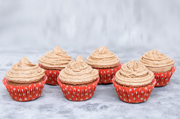 Cookies cupcakes with cream in paper form. On a gray smoky background.